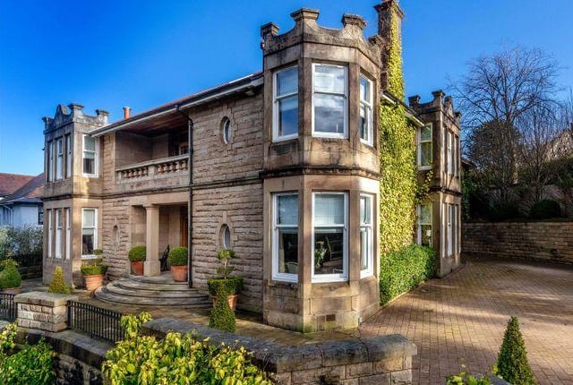 The drive way has space for several cars, and the house has a grand, sweeping staircase for a dramatic entrance.