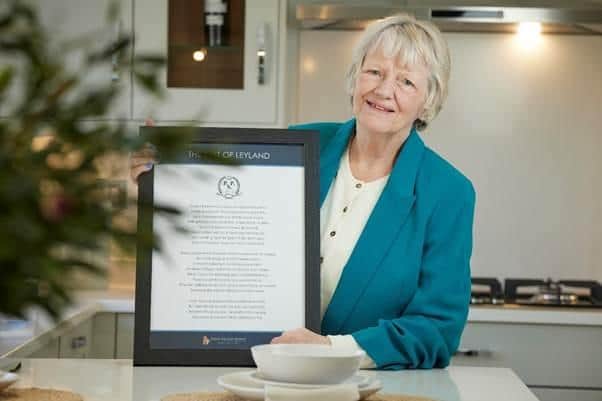 Dorothy Nelson with the framed copy of her 'Best of Leyland' poem in a David Wilson Homes show home.