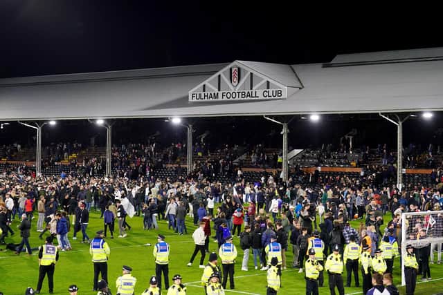 Fulham fans celebrate promotion on the Craven Cottage pitch after victory over Preston North End