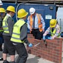 Bellway's John Campbell teaching children how to lay bricks