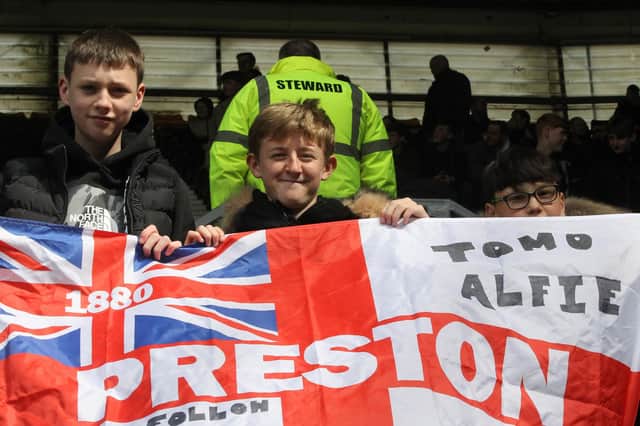 Three young North Enders with their flag in the away end at Pride Park