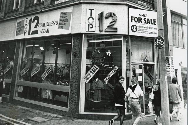 In 1988 estate agents were once again looking for a new client to claim the lease at this doomed property at the corner of Fishergate and Glovers Court in Preston. Despite being a prime location and a beautiful building, turnover at the spot was brisk. Pictured here is when it housed Top 12, a children's shop