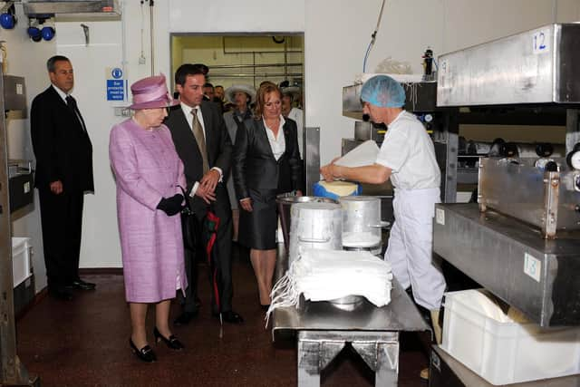 Queen Elizabeth II pictured with brother and sister Bill Riding and Tilly Carefoot watching the cheese making process during the royal visit to Singleton's Dairy in June 2008.