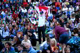 An England fan at Devonshire Green holds up a flag as they watch a screening of the UEFA Women's Euro 2022 semi-final match between England and Sweden held at Bramall Lane, Sheffield. Isaac Parkin/PA Wire.