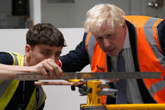 Prime Minister Boris Johnson receives a lesson in bricklaying