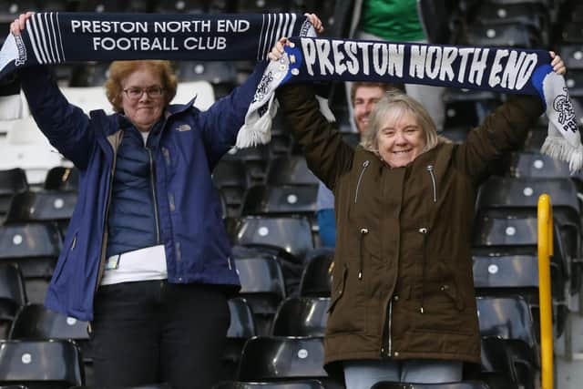 Preston fans hold scarves aloft