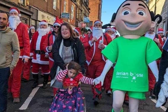 Riziah, 7, who visits Derian House, pictured with her mum Naomi Moazzeny and Derian mascot Danni