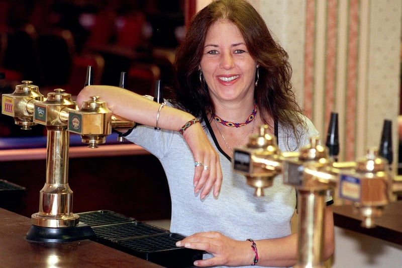 Landlady Lynda Pickwick behind the bar of the Larches Club, 1999