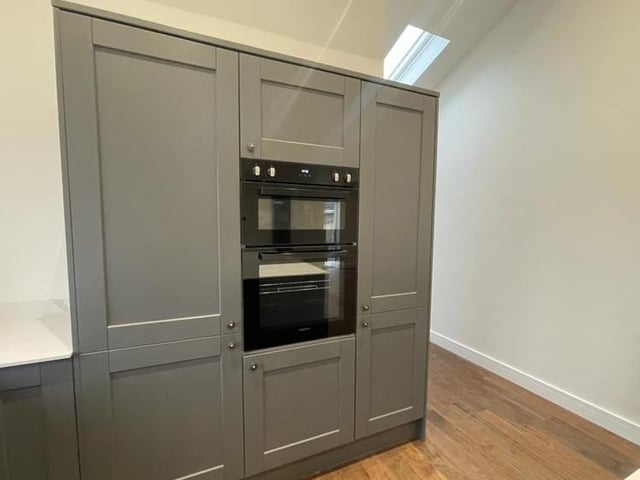 Integrated appliances in the dining kitchen include a built-in double oven, a fridge/freezer and dishwasher.