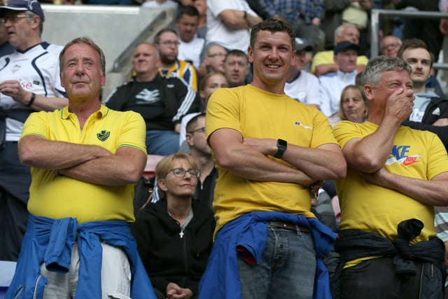 Three North End fans watch on in yellow.