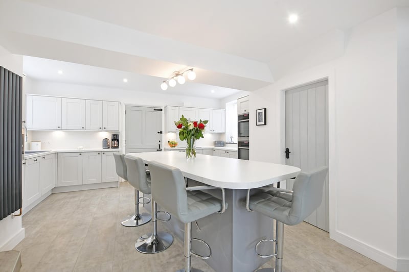 A contemporary breakfast kitchen, there’s a range of fitted base/wall and drawer units incorporating matching work surfaces, splash backs, under counter lighting and an inset 1.5 bowl Lamona sink with an extendable chrome mixer tap. Also there’s a central island with a matching work surface and providing further storage and breakfast seating for four chairs.