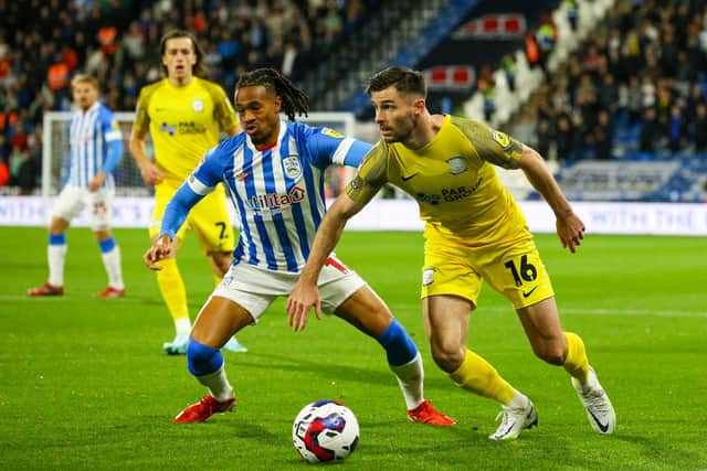 Preston North End's Andrew Hughes battles with Huddersfield Town's David Kasumu.