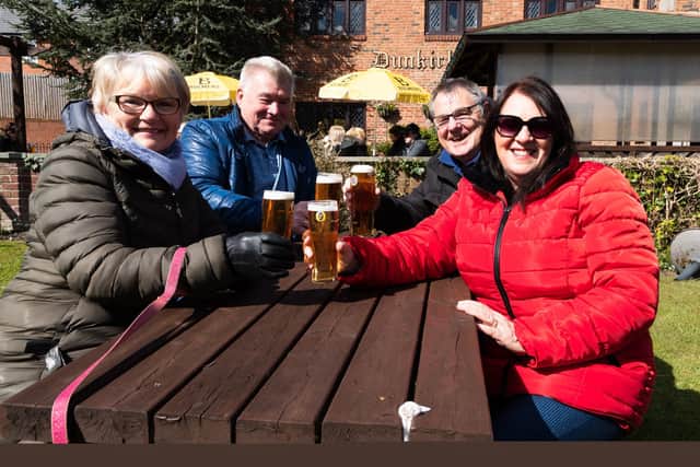 Customers celebrate the 2021 reopening of the Dunkirk Hall after lockdown with a pint. Photo: Kelvin Stuttard