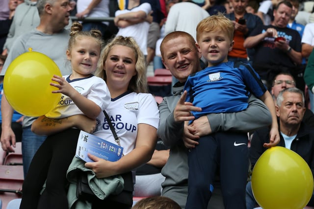 A couple of young Preston fans are ready with their yellow balloons to support their team.