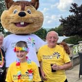 Alfie Hale at the end of his walk a mile a day challenge for Pendleside Hospice with his parents Jane and Gordon and hospice mascot Penny