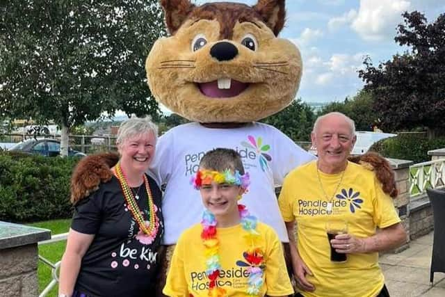 Alfie Hale at the end of his walk a mile a day challenge for Pendleside Hospice with his parents Jane and Gordon and hospice mascot Penny