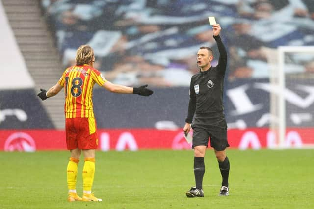 Stuart Attwell shows a yellow card to West Brom's Conor Gallagher. (Photo by JULIAN FINNEY/POOL/AFP via Getty Images)