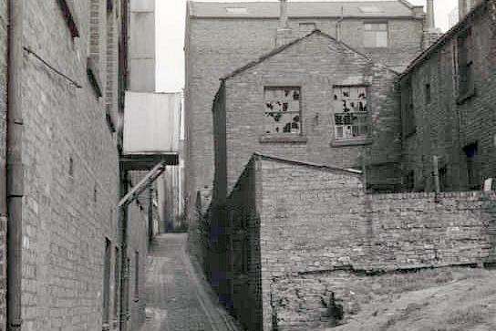 Old Cock Yard, Preston 1950
Old Cock Yard runs parallel to Avenham Street on the west side. This property was occupied for many years by George Millington, grate fixer and general ironmonger, and was demolished in 1959 to make way for a new warehouse for E.H.Booth and Company Limited of Fishergate, Preston. 

