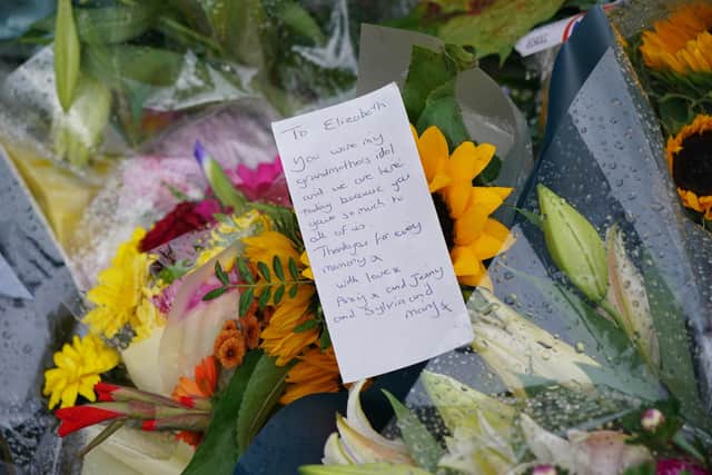 Flowers with a message left outside Buckingham Palace, London, following the death of Queen Elizabeth II on Thursday. Picture date: Friday September 9, 2022.