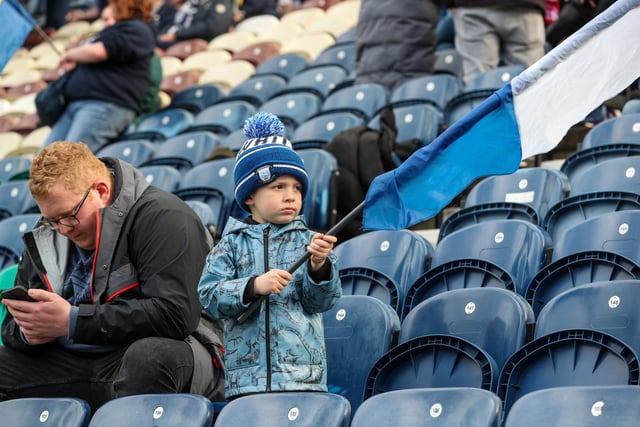 A young Preston North End fan waves a flag