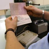 An immigration officer checking a passport at Heathrow Airport.