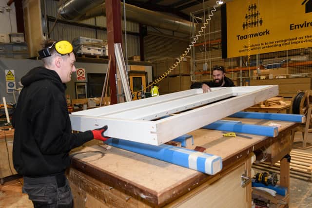 Joiners Stevie Bell and Louie Brian place a door frame on a table ready to start the next step of construction. Photo: Kelvin Stuttard