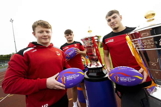 The Rugby League World Cup (2021) trophies at UCLan Sports Arena with UCLan students and Wales Rugby League players. (L-R) Kieran Lewis who is part of the senior team training squad, Mason Philips and Billy Walkley who both play for Wales under 19s.