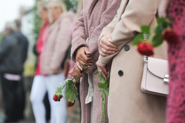 Some mourners held roses to throw on the coffin