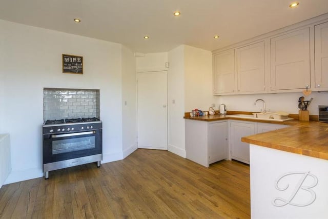 A second view of the kitchen, which is fitted with a range of integrated appliances, plus an inset sink and drainer and a complementary work surface over. There is also plenty of room for an oven.