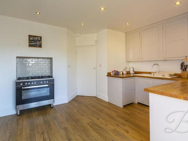 A second view of the kitchen, which is fitted with a range of integrated appliances, plus an inset sink and drainer and a complementary work surface over. There is also plenty of room for an oven.