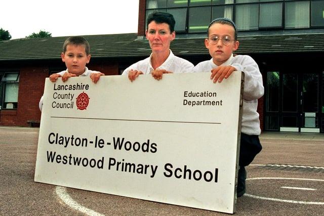 Lynne Schneidereit, the deputy head teacher of Westwood Primary School, Clayton-le-Woods near Preston, holds a vandalised sign assisted by pupils, Peter Harvey and Louise Worth