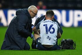 Preston North End defender Andrew Hughes receives treatment from club doctor Dominic Lakeland and physio Matt Jackson during the Blackburn game