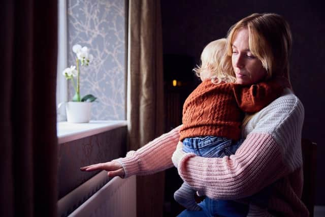 Trying To Keep Warm By Radiator At Home During Cost Of Living Energy Crisis. Photo: Monkey Business Images