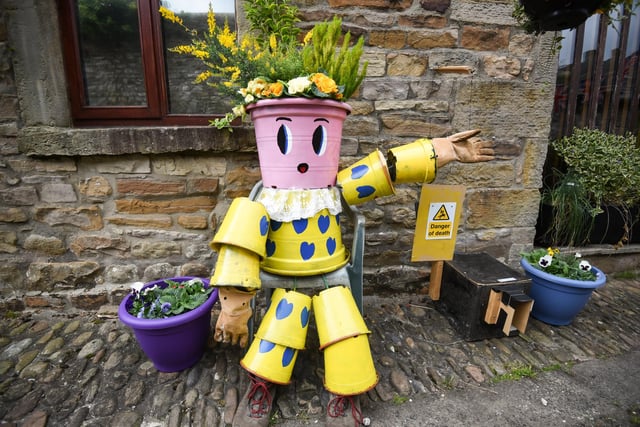A colourful flowerpot man points the way to the festival.