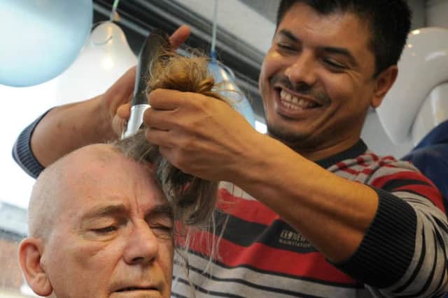 Peter Dalgleish, a volunteer at Preston and District RSCPA charity shop, Market Street, Chorley, gets his long locks shaved off by barber Ali