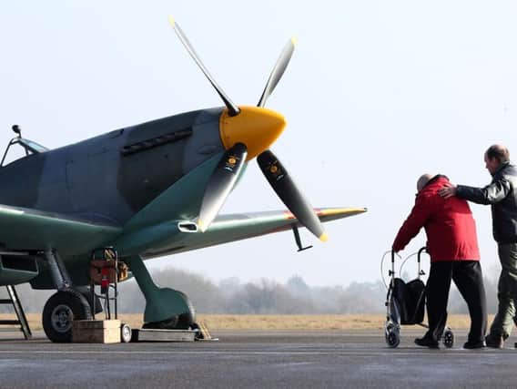 Former Spitfire pilot Ray Roberts is led to a Spitfire by Captain Peter Kynsey