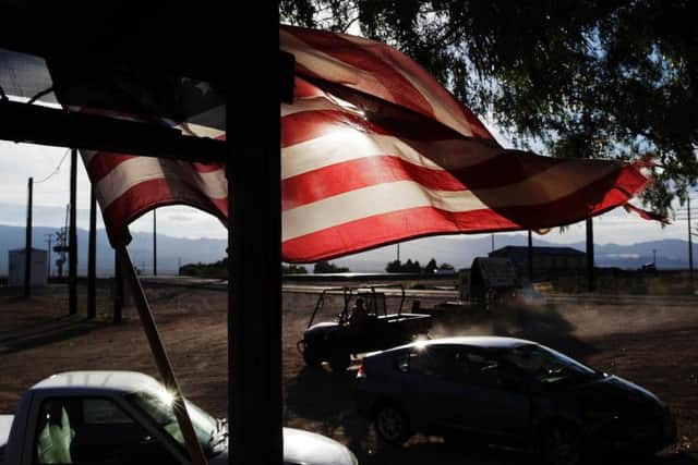 A flag flies in front of a store in Nipton, Calif
