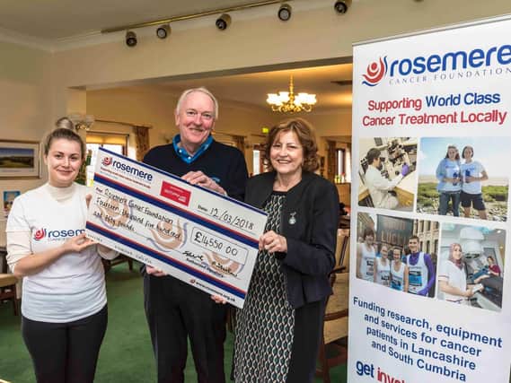 Rebecca Hall from of the Rosemere Cancer Foundation (left) collects the 14,550 donation from Geoff Charlson and Pauline Forshaw at Chorley Golf Club.