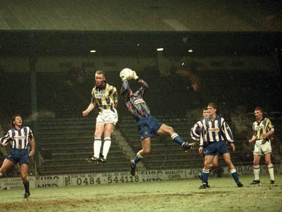 PNE striker Micky Norbury jumps with the Huddersfield goalkeeper