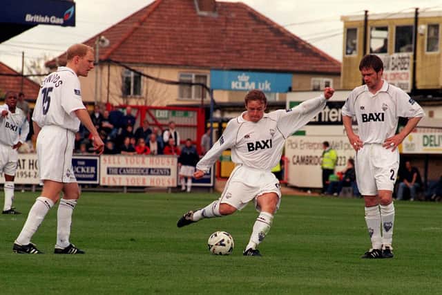 PNE midfielder Paul McKenna takes a free-kick against Cambridge watched by Rob Edwards and Graham Alexander