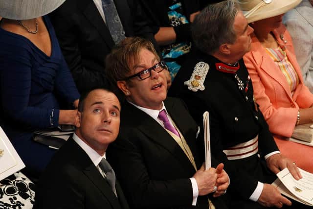 British singer Elton John (C) and his partner David Furnish (L) look up during the wedding ceremony of Britain's Prince William and his wife Kate, Duchess of Cambridge