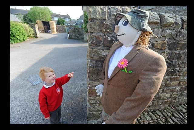 Adam Mackley, aged 5, with one of the scarecrows