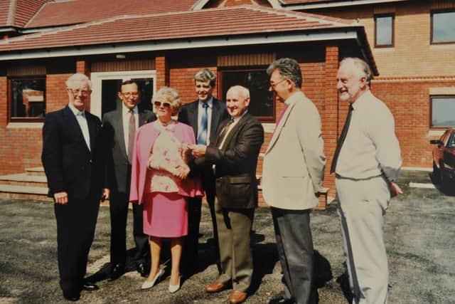 The builder of Derian House, Bert Ainscough handing over the keys to Margaret Vinten accompanied by the Trustees: Douglas McMillan, Rick Thomas, Alan Chesters, who was Bishop of Blackburn, and Leo Duffy, in 1993