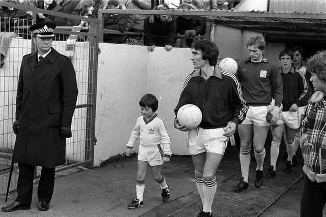 Preston captain Francis Burns and a young mascot lead the team out against Notts County at Deepdale in December 1978