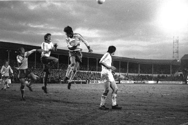 PNE centre-half Mick Baxter rises between two Notts County players at Deepdale