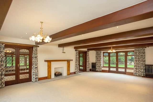 Off the galleried reception room, the living room features a grand fireplace and original beams.