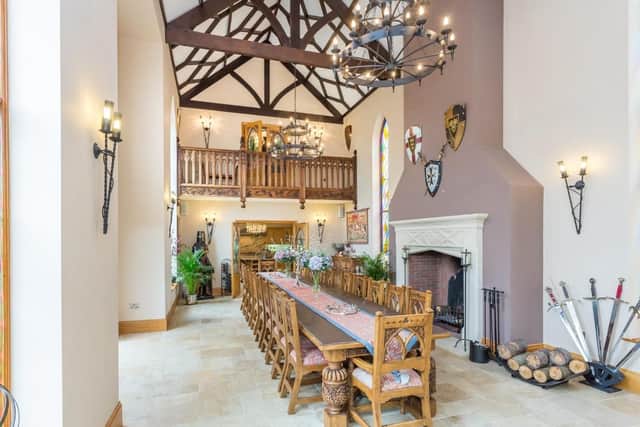 It also has a vaulted ceiling with decorative beams as well as a galleried balcony and a limestone fireplace.