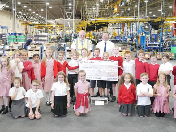 James Woodhouse, (behind the centre of the cheque) with his classmates from Clayton-le-Woods Primary School at Leyland Trucks
Behind him is Stuart Derbyshire (Cycle Ride Organiser) and Matt Kersey (Helping Hand Chairman)