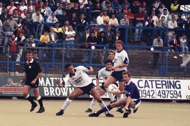 Preston centre-half Mike Flynn puts in a tackle against Torquay as Ronnie Jepson and Gary Swann look on