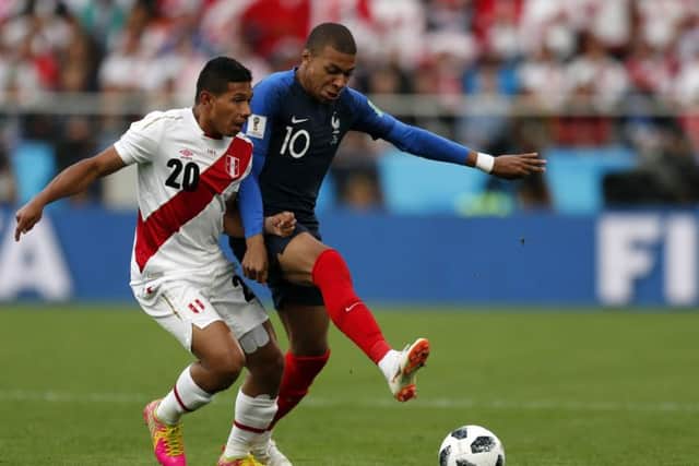 France's Kylian Mbappe is challenged by Peru's Edison Flores in their Group C clash